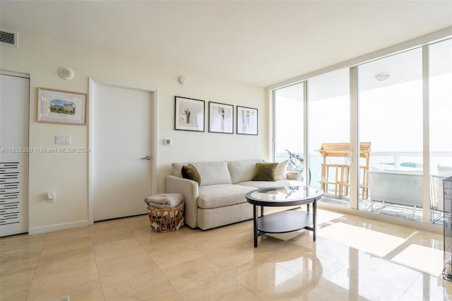 living room featuring a wall of windows and light tile patterned floors