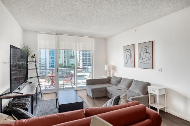 living area featuring floor to ceiling windows, a textured ceiling, baseboards, and wood finished floors