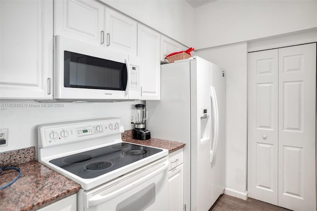 kitchen featuring baseboards, stone counters, wood finished floors, white cabinets, and white appliances