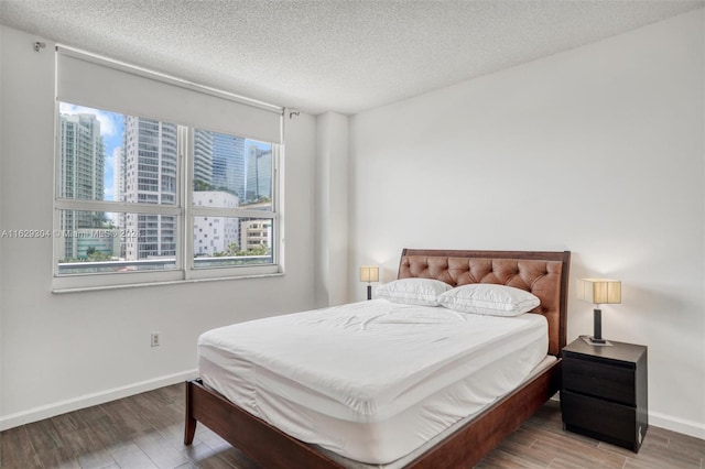 bedroom with a textured ceiling and hardwood / wood-style floors