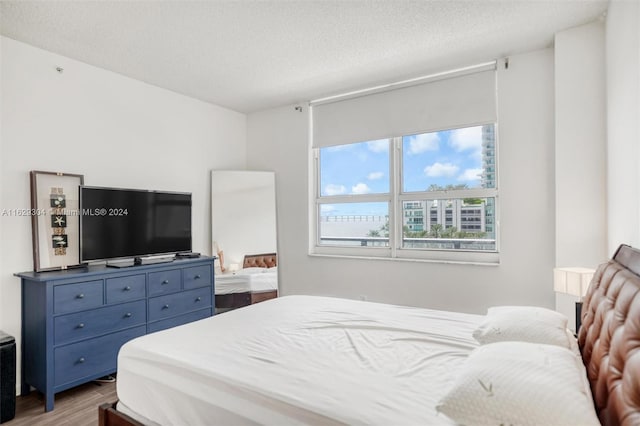 bedroom featuring a textured ceiling and hardwood / wood-style floors