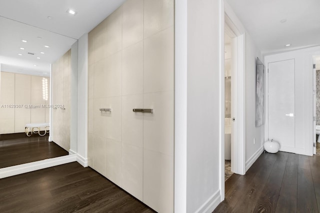 hallway featuring dark hardwood / wood-style floors and tile walls