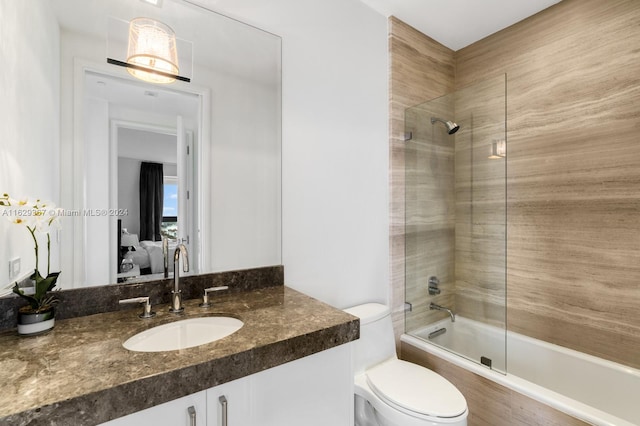 full bathroom with toilet, tiled shower / bath combo, and vanity