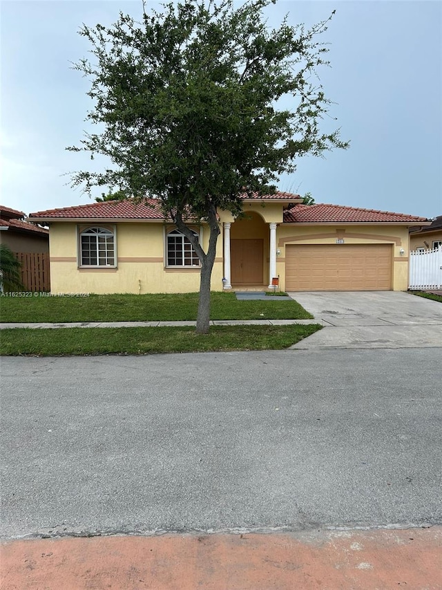 mediterranean / spanish house with a garage and a front yard