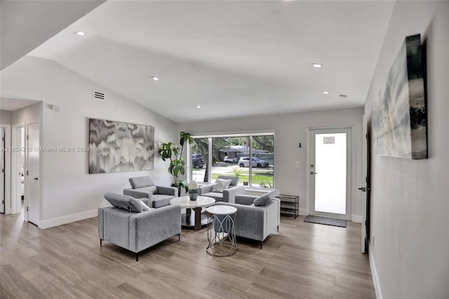 living room featuring lofted ceiling and light wood-type flooring