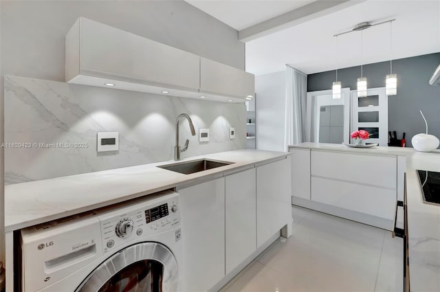 interior space with sink, washer / clothes dryer, and light tile patterned flooring