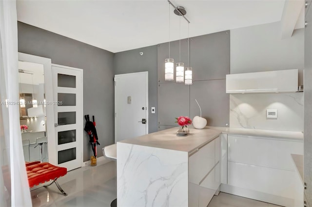 kitchen with pendant lighting, white cabinets, and kitchen peninsula