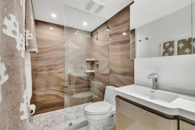 bathroom with tile walls, toilet, vanity, and walk in shower