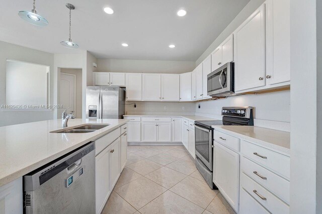 kitchen with stainless steel appliances, white cabinets, sink, decorative light fixtures, and light tile patterned floors