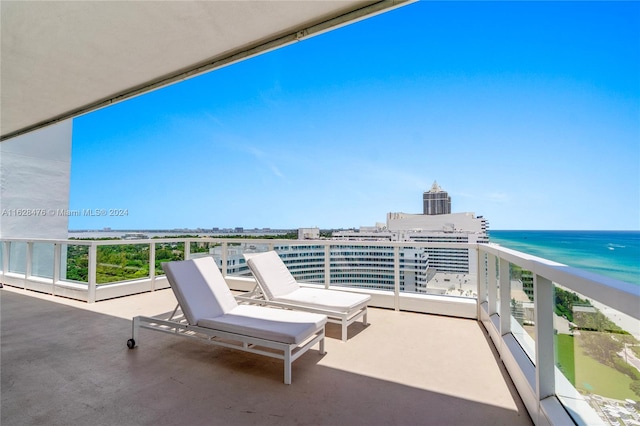 balcony featuring a view of the beach and a water view