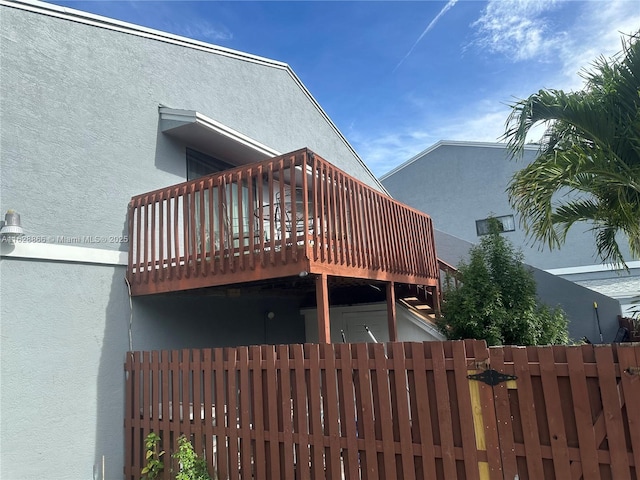 22 Crossings Cir Unit E, Boynton Beach, FL 33435 - back of house featuring stucco siding and a wooden deck