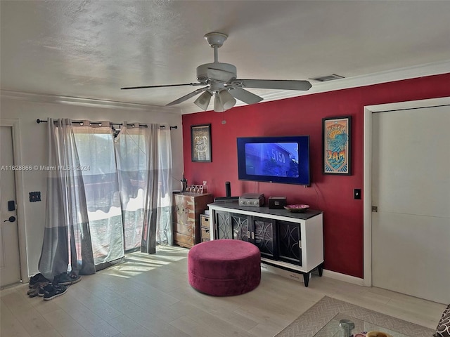 living room featuring light hardwood / wood-style floors, crown molding, and ceiling fan