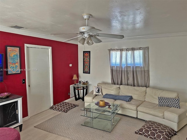 living room featuring wood-type flooring, crown molding, and ceiling fan