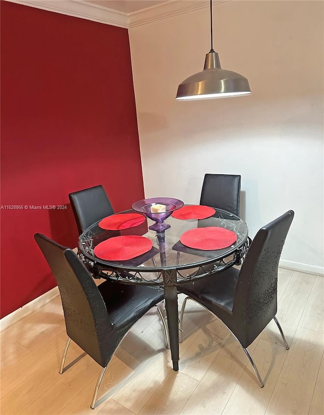 dining space featuring light hardwood / wood-style flooring and ornamental molding