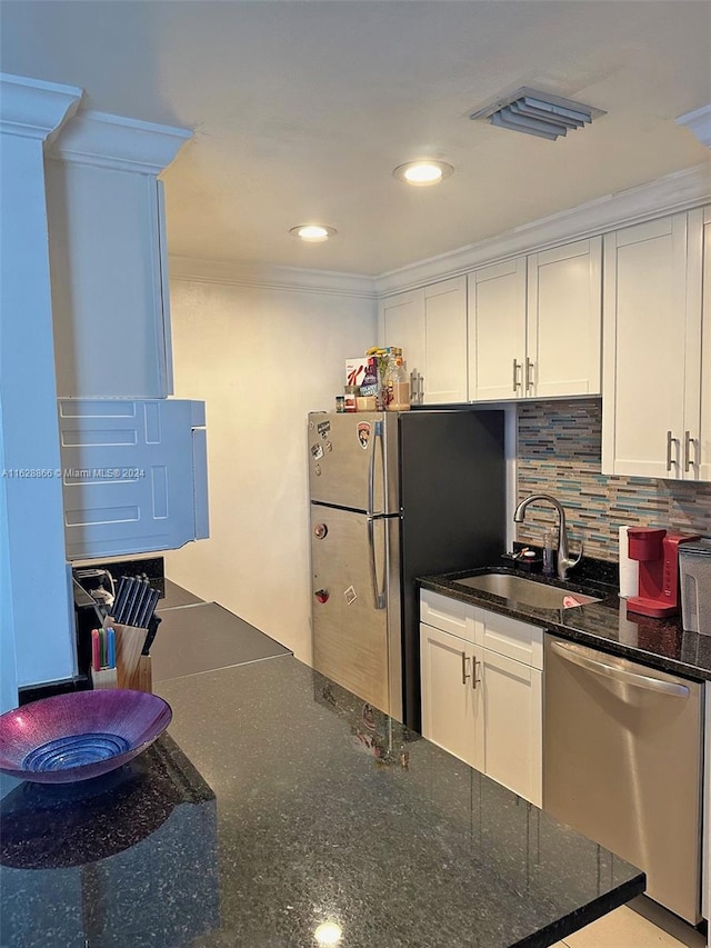 kitchen featuring dishwasher, dark stone counters, tasteful backsplash, and white cabinets