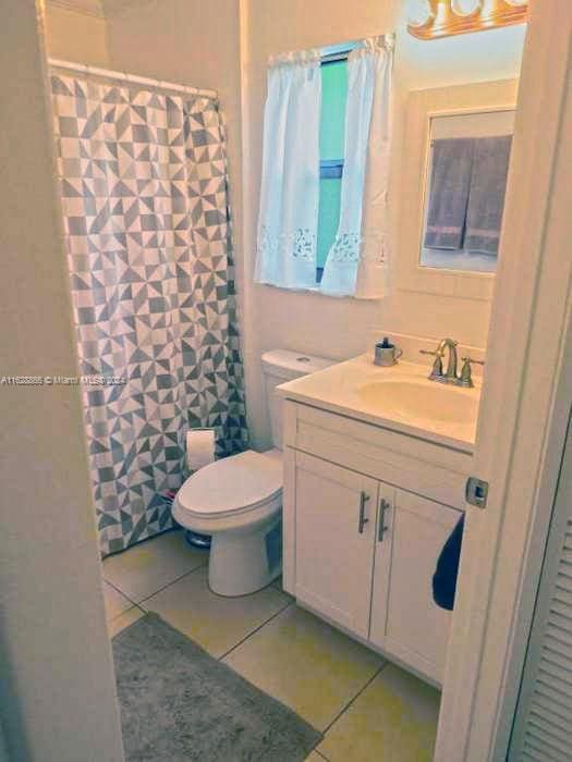 bathroom featuring vanity, tile patterned flooring, and toilet