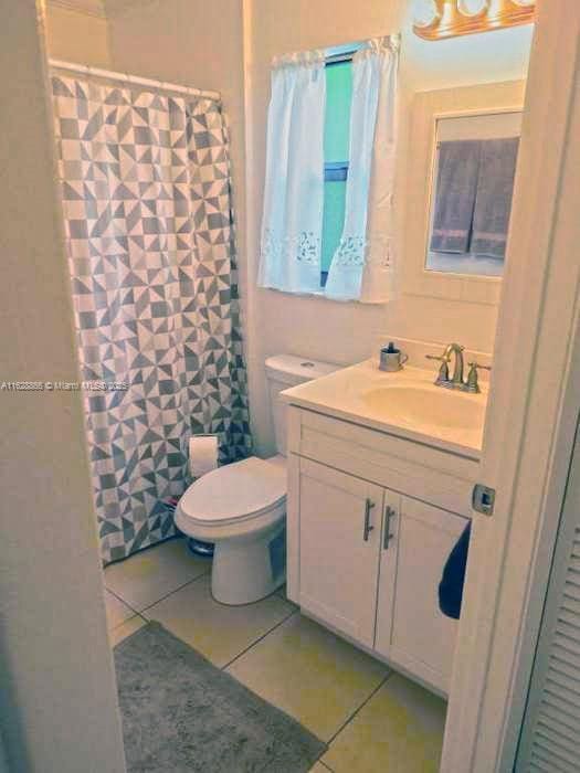 22 Crossings Cir Unit E, Boynton Beach, FL 33435 - bathroom featuring tile patterned floors, vanity, and a shower with curtain