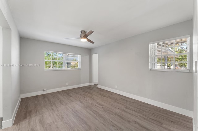 unfurnished room featuring hardwood / wood-style floors, a wealth of natural light, and ceiling fan