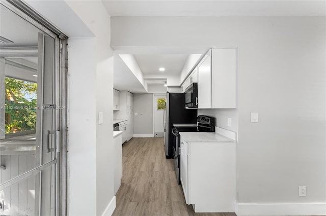 kitchen featuring light stone countertops, white cabinetry, light wood-type flooring, and black range with electric cooktop