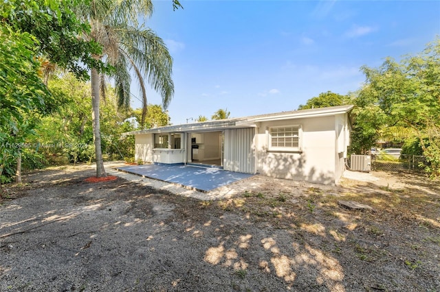 rear view of property featuring central AC and a patio area