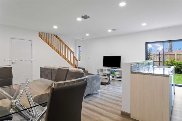 dining space featuring a wealth of natural light, sink, and light hardwood / wood-style flooring