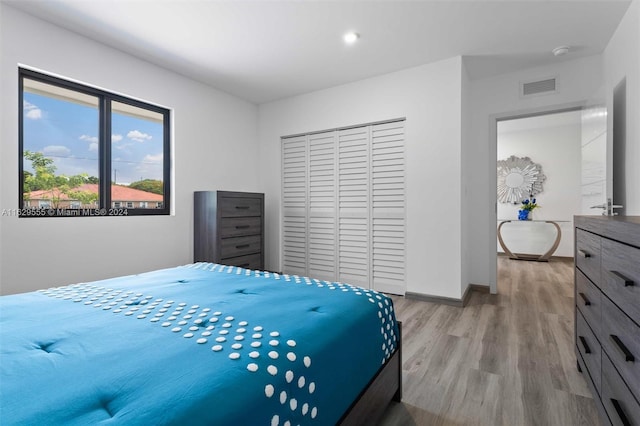 bedroom with light hardwood / wood-style floors and a closet