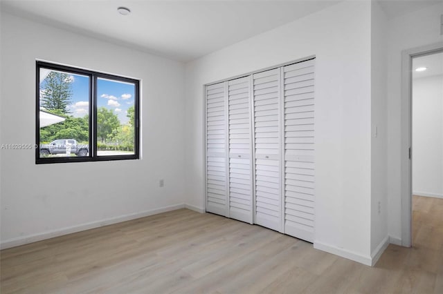 unfurnished bedroom with a closet and light hardwood / wood-style flooring