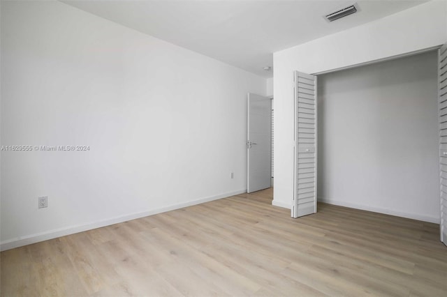 unfurnished bedroom featuring a closet and light hardwood / wood-style flooring