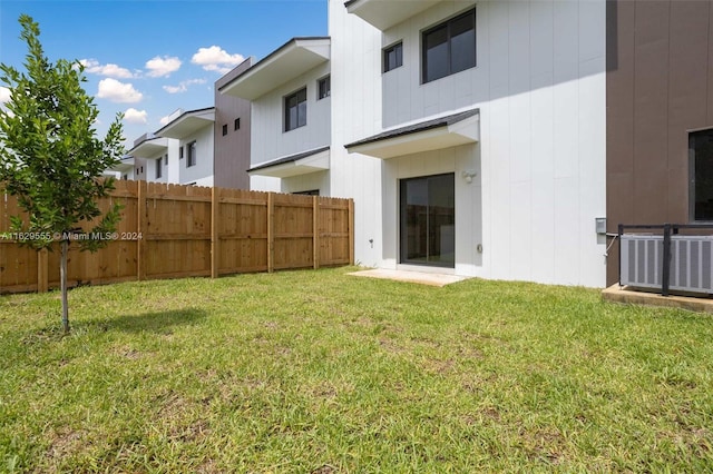 back of house with a lawn and central AC unit