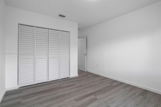 unfurnished bedroom featuring hardwood / wood-style floors and a closet