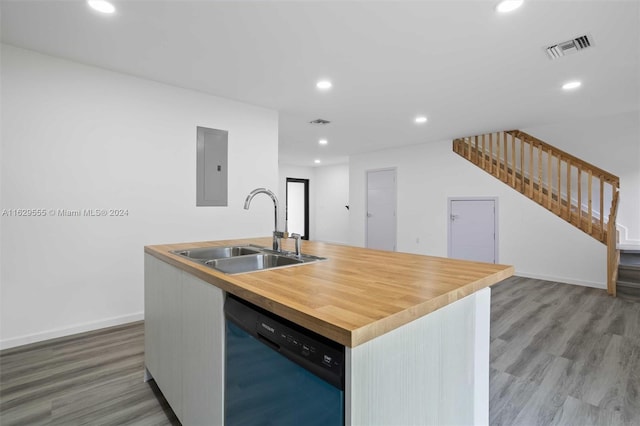 kitchen featuring sink, dishwasher, hardwood / wood-style floors, electric panel, and an island with sink