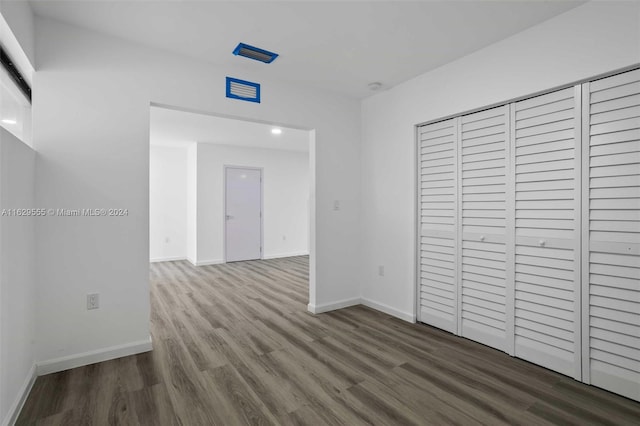 unfurnished bedroom featuring a closet and hardwood / wood-style floors