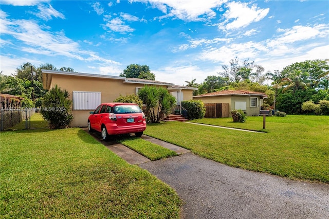 single story home with a front yard, fence, and stucco siding