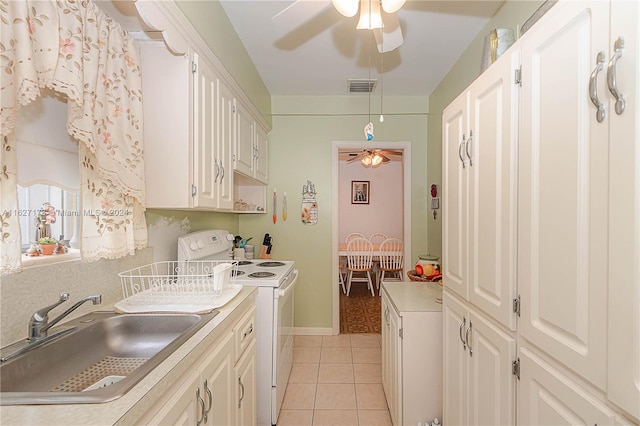 kitchen with light tile patterned floors, white range with electric stovetop, visible vents, light countertops, and a sink