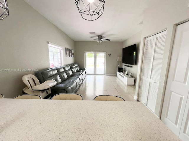 tiled living room with vaulted ceiling, ceiling fan, and french doors