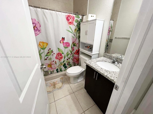 bathroom featuring tile patterned flooring, vanity, walk in shower, and toilet