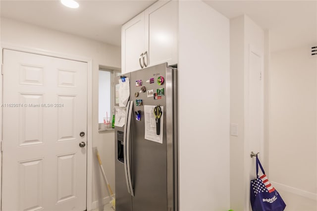 kitchen with stainless steel refrigerator with ice dispenser and white cabinets