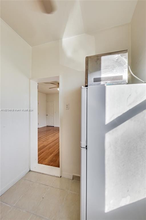 kitchen with light hardwood / wood-style floors, white fridge, and ceiling fan