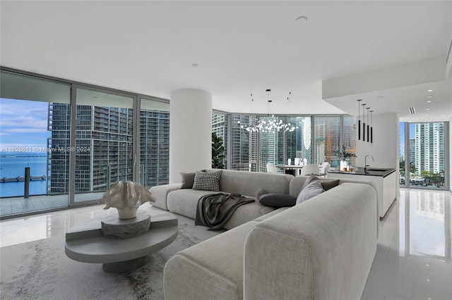 living room featuring floor to ceiling windows, sink, and a chandelier