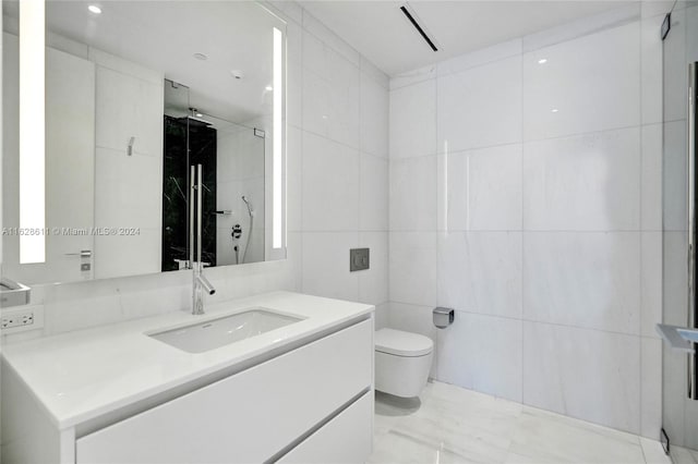 bathroom featuring tiled shower, vanity, toilet, and tile walls