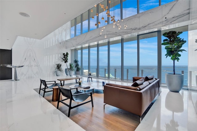 living room with a water view, expansive windows, and wood-type flooring