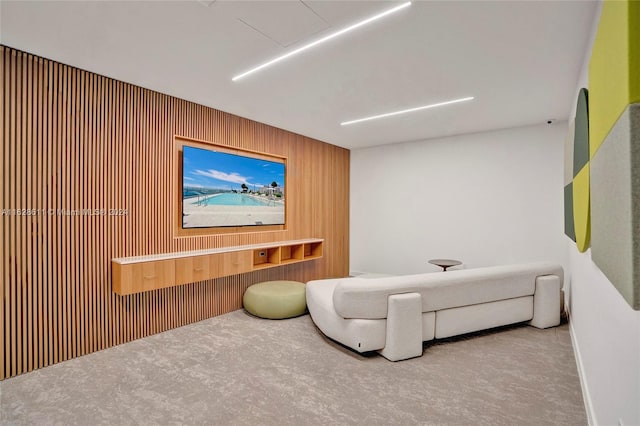 sitting room with carpet flooring and wood walls