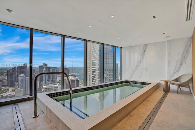 view of swimming pool featuring a water view and a hot tub