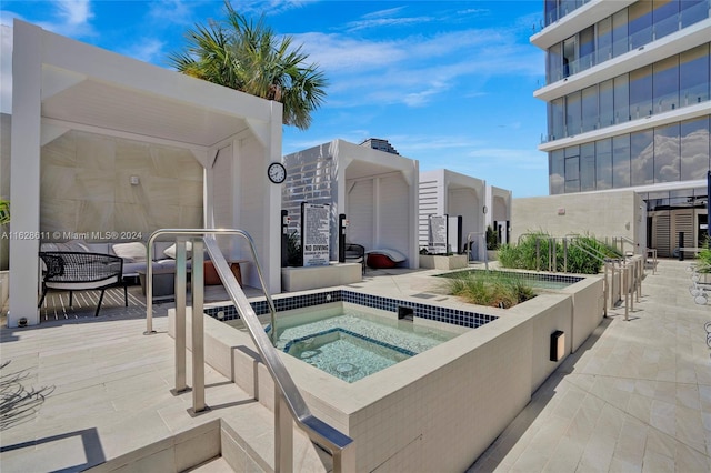 view of pool with a hot tub and a patio area