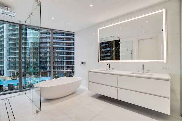 bathroom featuring tile patterned flooring, separate shower and tub, and vanity