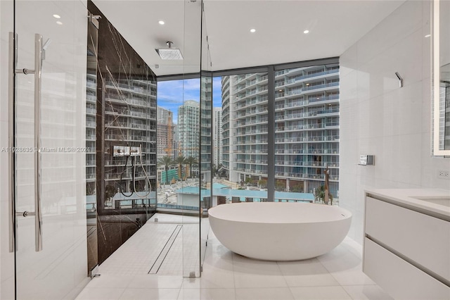 bathroom with tile patterned floors, floor to ceiling windows, shower with separate bathtub, and vanity