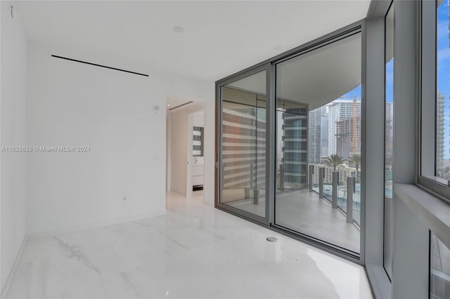 spare room featuring floor to ceiling windows and concrete floors