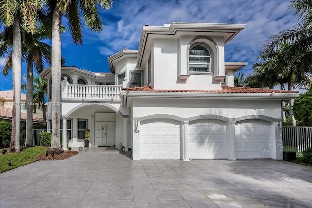 mediterranean / spanish-style home featuring a garage and a balcony