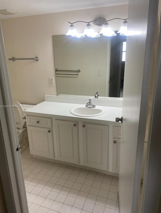 bathroom featuring vanity, tile patterned flooring, and toilet