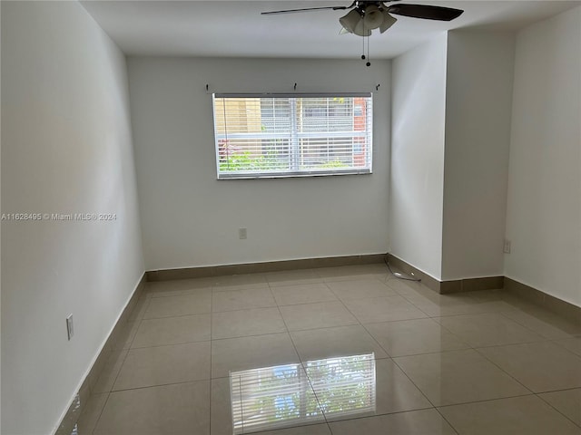 empty room with light tile patterned floors and ceiling fan